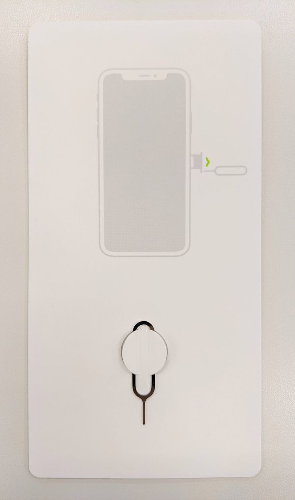 SIM 取り出しツールが取り付けられている紙