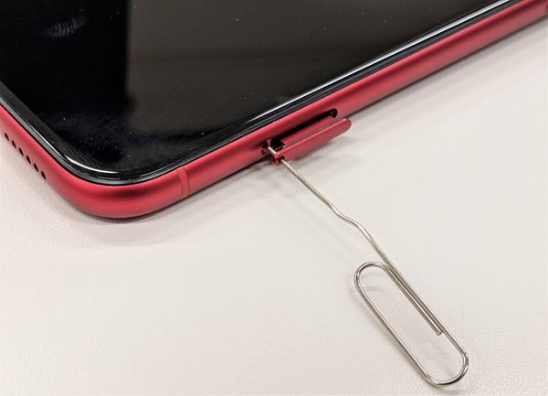 ペーパークリップでSIM トレーを開いた様子