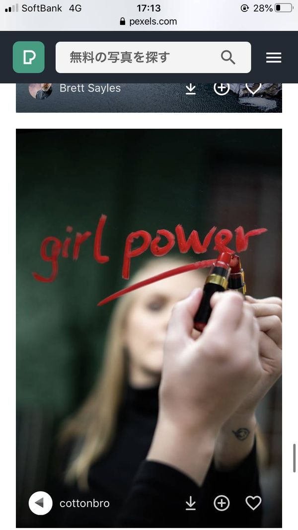 女性が鏡に「girl power」と口紅で描いている画像