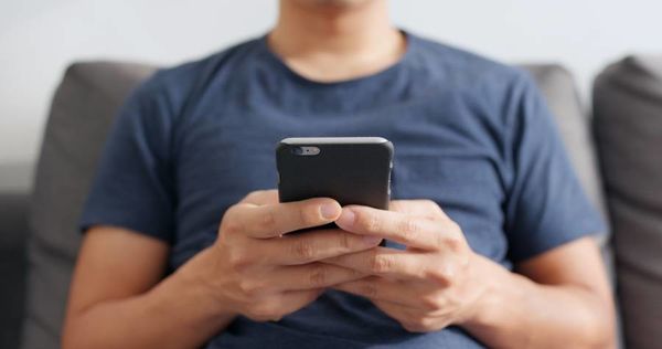 男性がスマートフォンを触っている