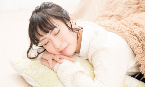 こたつで眠る女性