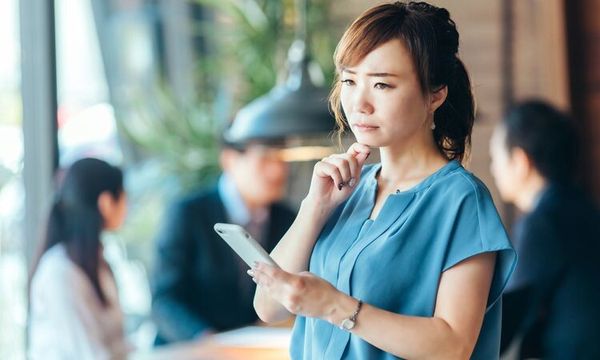 取引先と連絡が取れずに困る女性