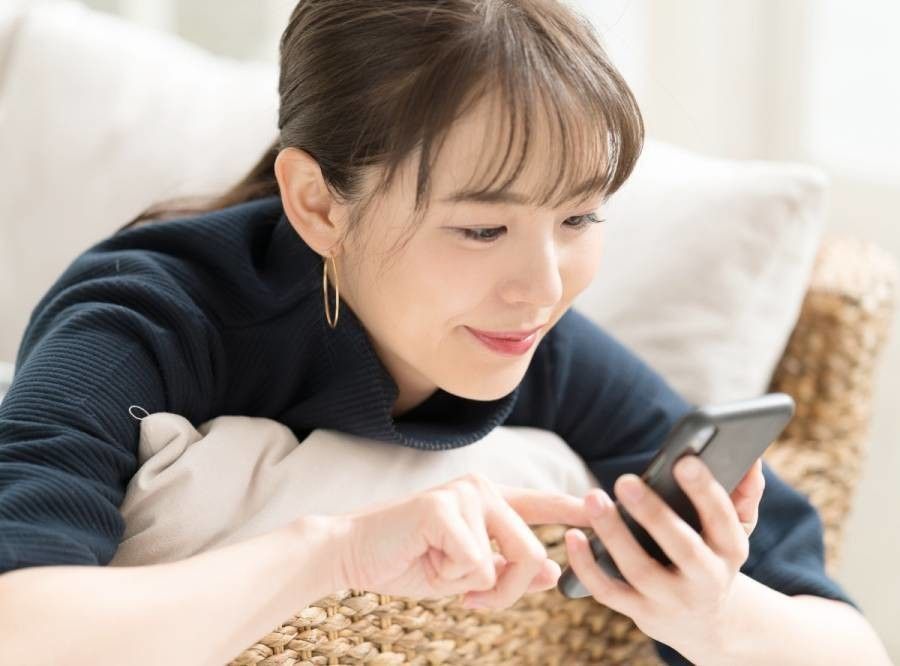 スマホを操作している女性の画像