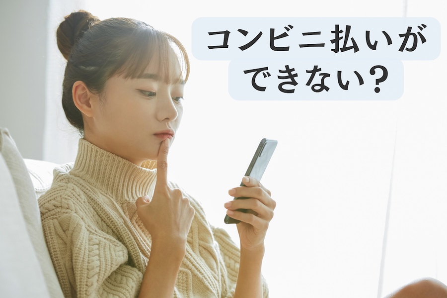 スマホを見ながら悩む女性の画像