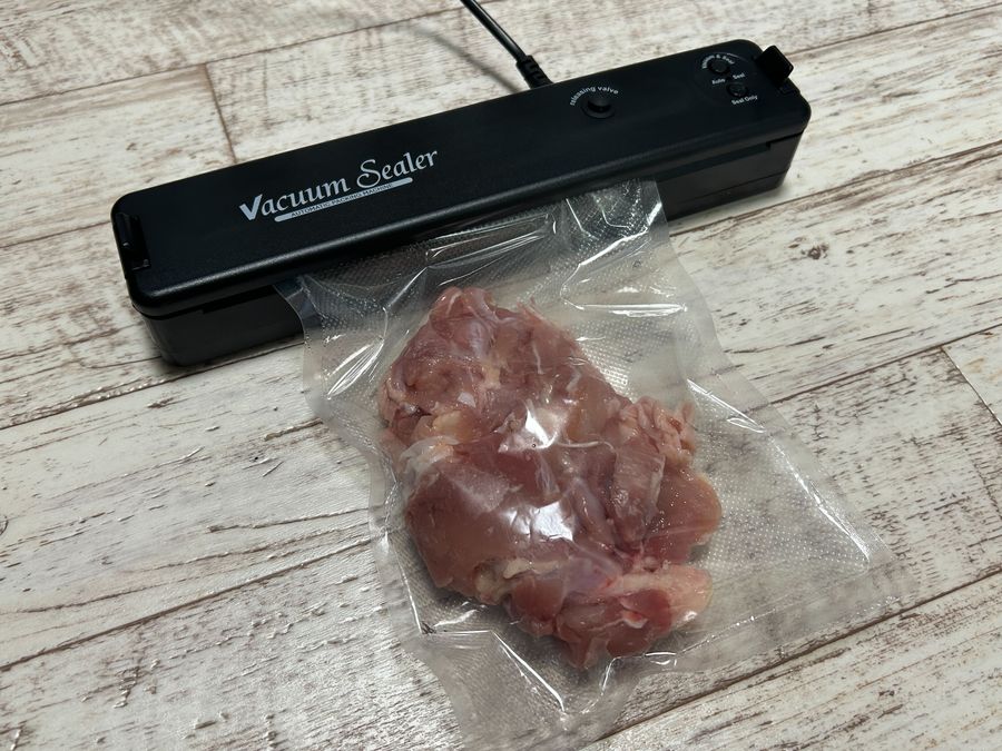 真空シーラーで鶏肉をパックしている写真